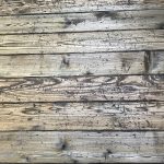 Wood deck surface showing signs of wear and discoloration, relevant to deck restoration and maintenance discussions.